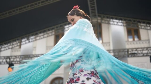 Spanish flamenco dance on stage outside, professional beautiful girl dancing with scarf. Striking elegance in motion. Female flamenco dancer in gypsy costumes