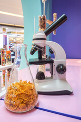 Microscope with simulated test tubes filled with multi-colored chocolate beads.