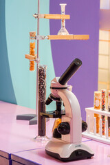 Microscope with simulated test tubes filled with multi-colored chocolate beads.