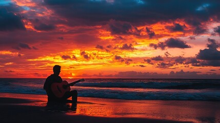 A man plays a guitar on the beach at sunset.