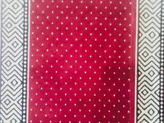 The texture of the red carpet with a white dot motif neatly arranged in a straight line gives an elegant impression as a background for industrial product catalog design.