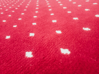 The texture of the red carpet with a white dot motif neatly arranged in a straight line gives an elegant impression as a background for industrial product catalog design.