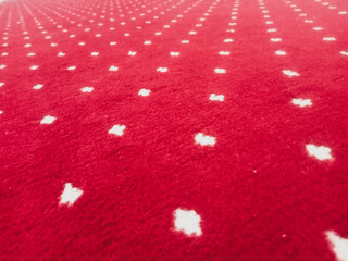 The texture of the red carpet with a white dot motif neatly arranged in a straight line gives an elegant impression as a background for industrial product catalog design.
