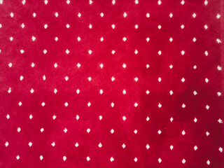 The texture of the red carpet with a white dot motif neatly arranged in a straight line gives an elegant impression as a background for industrial product catalog design.