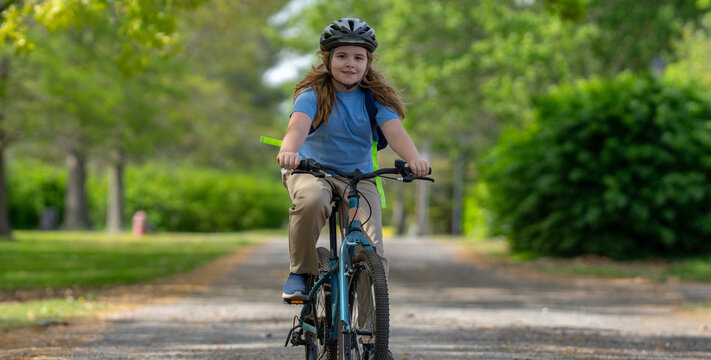 Child bike ride. Child biking down summer road. Kid riding bicycle with smile. Kid cycling. Kid ride on bike. Happy boy on bike. Kid biking outdoors. Children biking. Little biker.