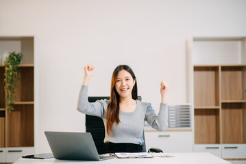 Asian business woman typing laptop and tablet Placed at the table at the office
