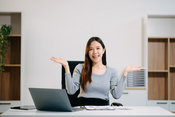 Asian business woman typing laptop and tablet Placed at the table at the office