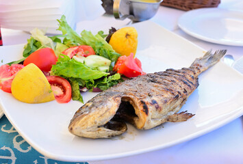 gegrillte Dorada mit gebratenem kartoffeln und frischen gemüsen