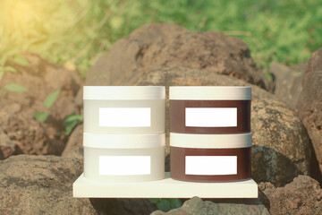 
A product mockup showcasing two sets of cosmetic jars, one white and one brown, each with a blank label.