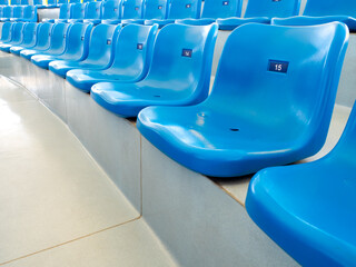 Empty blue plastic seats or stadium chairs with numbers in aquarium show or stadium. Rows of seats pattern, on the steps with nobody.