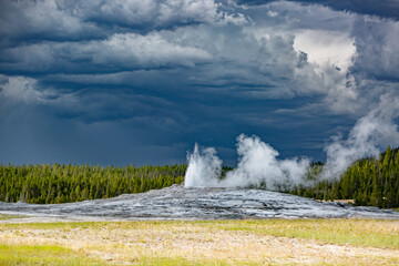 Old Faithful Geyser Beginning to Erupt under Stormy Sky – Yellowstone National Park