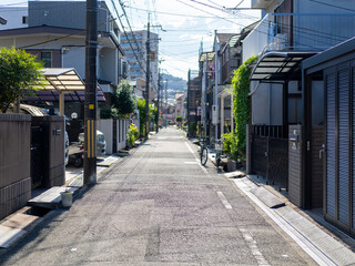 夏の日射しに照らされた住宅街の路地
