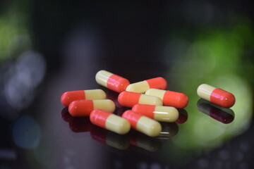 Illustration of various capsules used for treatment against a dark background