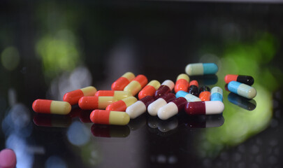 Illustration of various capsules used for treatment against a dark background
