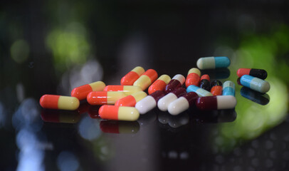Illustration of various capsules used for treatment against a dark background
