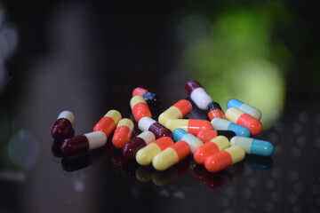 Illustration of various capsules used for treatment against a dark background