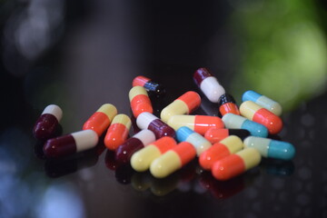 Illustration of various capsules used for treatment against a dark background
