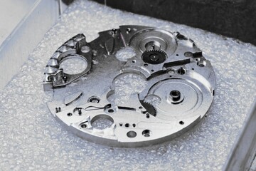 Intricate components of watch mechanisms showcased in a meticulous metalworking environment of a watch factory