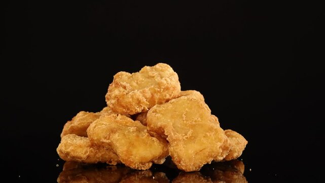 Golden Fried Chicken Nuggets Rotating on Black Background