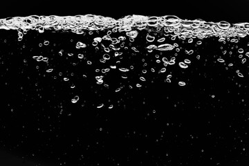 黒の背景に水中に舞い上がるたくさんの気泡.