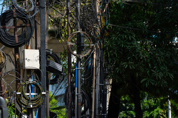 messy urban utility and electrical wire on electric pole in Indonesia, during sunny weather