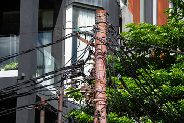messy urban utility and electrical wire on electric pole in Indonesia, during sunny weather