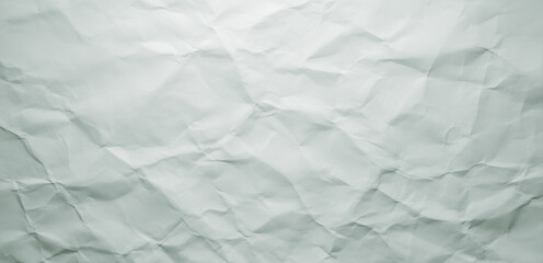 Obraz premium Crumpled white paper texture with shadows and folds creating an abstract pattern.premium paper texture photo for poster, banner, and pamphlet background