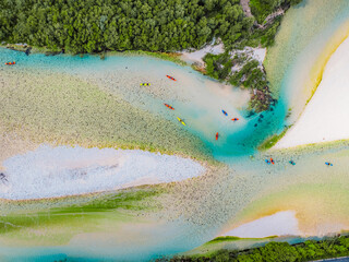 Rafting and kayaking place on the river. Kayakers in colorful life jacket paddling in Soca river,...