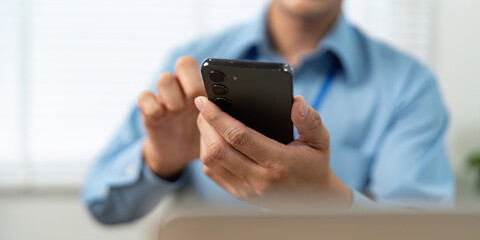 Mobile Communication. Businessman using smartphone in office.