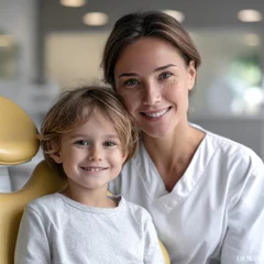 Fotobehang Tandarts Smiling dentist and young boy in modern dental clinic, cheerful atmosphere, dental care, healthy teeth, professional service  © visoot