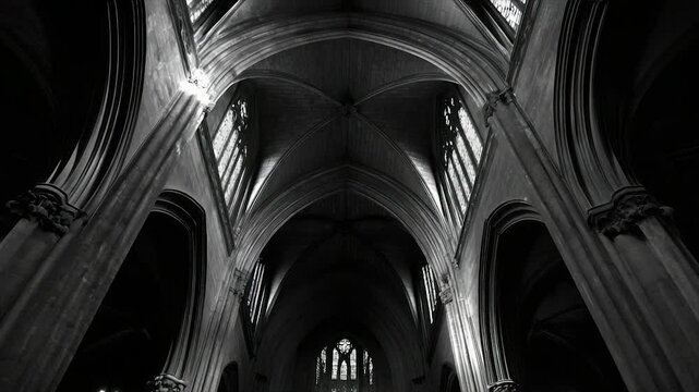 Monochromatic interior shot of a gothic cathedral's vaulted ceiling and high arched windows, showcasing architectural grandeur