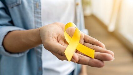 Holding the Yellow Ribbon: The image showcases a person's open hand, delicately holding a bright yellow ribbon. It’s a powerful symbol of hope, support, and solidarity.