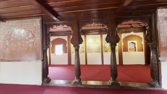 A slow pan reveals a beautifully detailed painting hanging on the wall of a room in Nana Fadnavis Wada, Wai, Maharashtra, framed by an elegant wooden ceiling and traditional Maratha architecture 4K