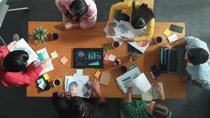 Top view of skilled businessman present marketing idea at meeting while group of investor listening and planning strategy while looking at stock market chart or data analysis document. Convocation. - Powered by Adobe
