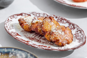 Baked potatoes with parmesan in bright lighting, overhead restaurant-style composition