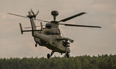 Modern assault helicopter during takeoff from field airstrip