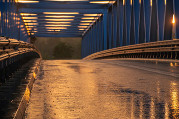 Wet asphalt road after evening storm running through industrial area