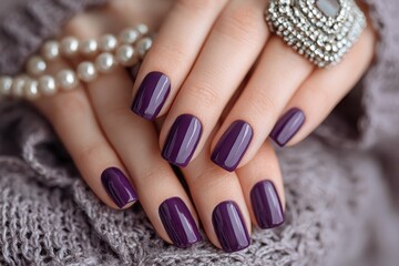 Close-up of woman's hands with dark purple polished nails and ring. Can be used for beauty, fashion and personal care projects.