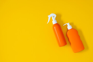 Two different tubes of sunscreen with cream on a yellow background. Sun protection. UV protection. Summer. Top view.