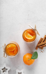 Top view of jars with Homemade tangerines jam with orange peel on white background, copy space