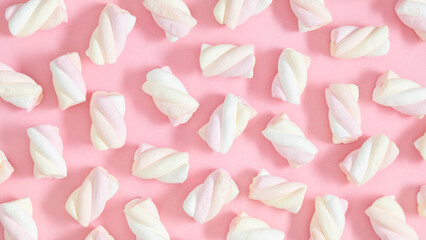 Pattern of marshmallows on a multicolored pink background, top view, flat lay. Marshmallow candies for background. Banner