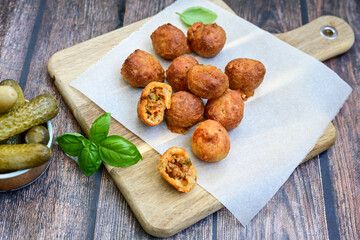Mini cheese  burger balls.  Ball shaped snack with meat, pickled cucumbers and tomato on wooden background
