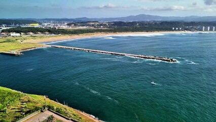 This stunning aerial view highlights the coast and pier, nestled among serene blue waters and...