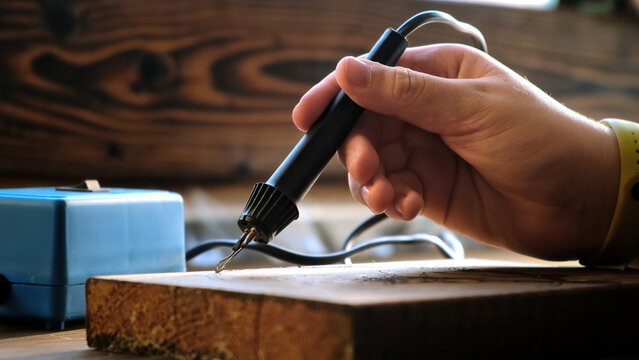 Burn out the picture. Woodburning or pyrography. An artist drawing on a wooden plank with pyrograph. Wood burning ASMR creative hobby. Art class workshop. Creative activity. High quality 4k footage.