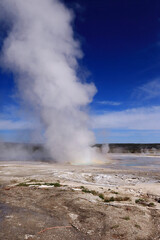 Gray thick steam rises from a geothermal source. Ahead is a gray lifeless land