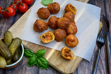 Mini cheese  burger balls.  Ball shaped snack with meat, pickled cucumbers and tomato on wooden background