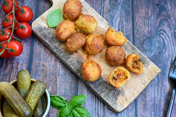 Mini cheese  burger balls.  Ball shaped snack with meat, pickled cucumbers and tomato on wooden background