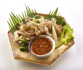 Boiled beef tendon served with spicy dipping sauce, garnished with fresh herbs and vegetables on decorative plate, creating flavorful and aromatic dish
