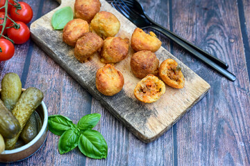 Mini cheese  burger balls.  Ball shaped snack with meat, pickled cucumbers and tomato on wooden...