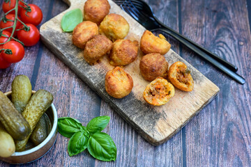 Mini cheese  burger balls.  Ball shaped snack with meat, pickled cucumbers and tomato on wooden...